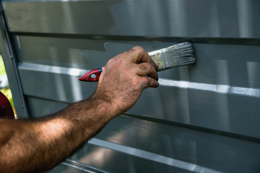 Hand painting a garage door.